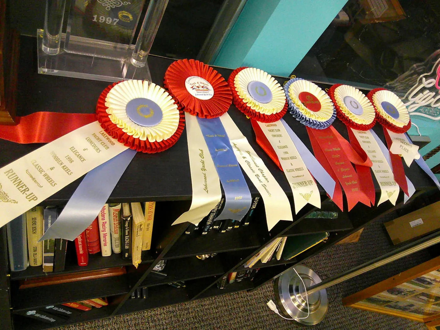 Row of Lakewood Yacht Club Concours d'Elegance rosettes and ribbons.