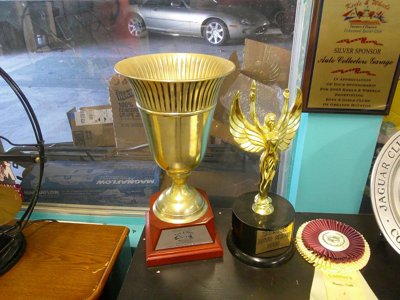 2005 Keels & Wheels Emeritus Award cup and 2009 Houston Auto Show trophy.